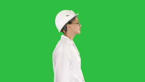 Scientist physicist woman walking in lab coat and hardhat on a Green Screen Stock Footage 99976856