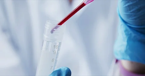Scientist with pipette analyzes red colored liquid to extract the DNA Stock Footage 126164144