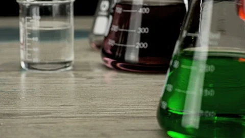Scientist places beaker on lab table Stock Footage 99747017