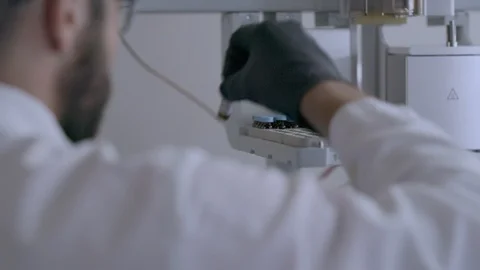 Scientist places test samples in a machine Video stock 92499624