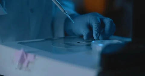 Scientist placing a liquid sample with micropipette on a glass plate at the lab Stock Footage 121167149