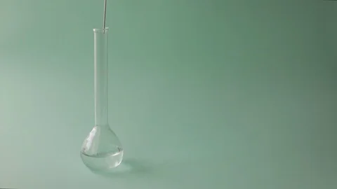 Scientist pouring blue colored liquid in a test tube. Liquids mixing on a blu Stock Footage