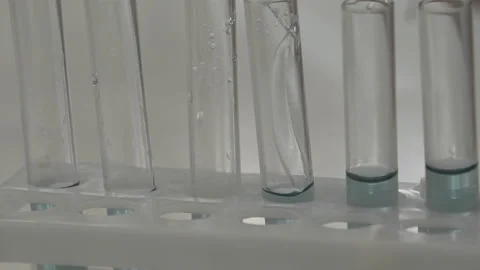Scientist pouring blue liquid in test tubes in a laboratory Stock Footage 95550602