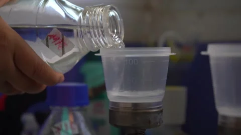 Scientist Pouring Clear Liquid into Laboratory Measuring Cup Vídeos de archivo 334181161