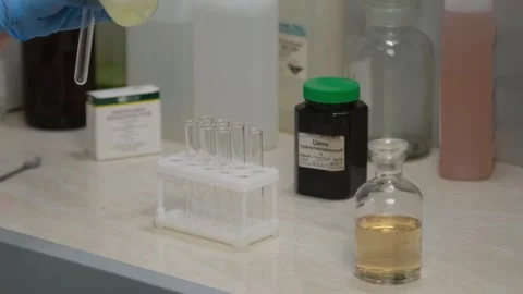 Scientist Pouring Liquid into Test Tubes in Laboratory Stock Footage 303369352