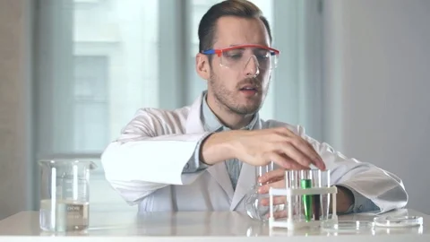 Scientist pouring red liquid from test tube into flask Stock-Footage 73111145