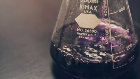 A Scientist Pours A Purple Liquid Into A Beaker Stock Footage 87534290