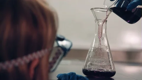 A Scientist Pours A Purple Liquid Into A Beaker Stock Footage 87534346