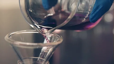 A Scientist Pours A Purple Liquid Into A Beaker Stock Footage 87534360