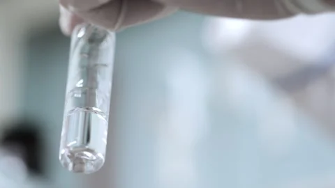 A scientist pours a sample into a test tube using a dispenser. Stock Footage 281701722