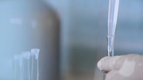 A scientist pours a sample into a test tube using a dispenser. Stock Footage 281701897