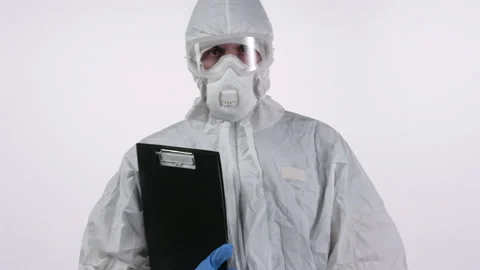 A scientist in PPE backing away with documents in hand, on a white background Stock Footage 297968972