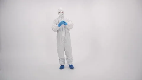 A scientist in PPE cleaning hands and coming closer on a white background Stock Footage 297964950