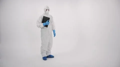 A scientist in PPE entering and verifying a medical record on a white background Stock Footage 297965945