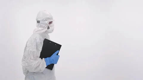 A scientist in PPE entering and verifying a medical record on a white background Stock Footage 297966236