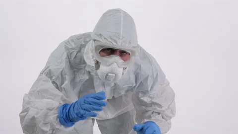 A scientist in PPE trying to touch the camera on a white background Stock Footage 297967985