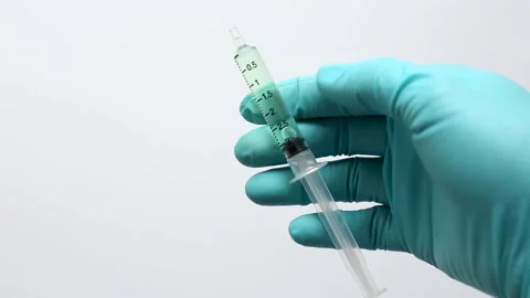 A scientist prepares a sample by attaching a syringe filter to a syringe Stock Footage 321970997