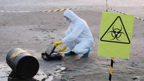 A scientist prepares to take samples of contaminated soil. Stock Footage 130660347