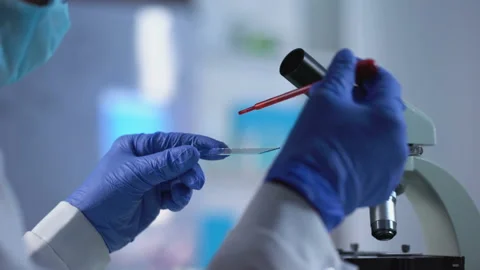 Scientist preparing blood sample and putting under microscope glass, biology 스톡 동영상 88196808