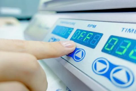 Scientist pressing button on machine Stock Photos