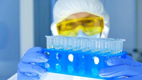 Scientist in protective clothes checking dangerous materials in test tubes in Stock Footage 108648541