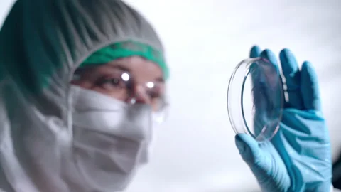 Scientist in protective coverall analyzing microorganisms on petri dish in 스톡 동영상 143879620