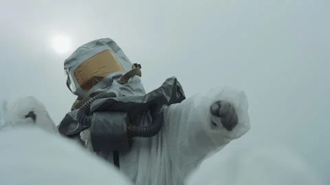 Scientist in protective gear examines contaminated snow cover. Researcher in 動画素材 342740502