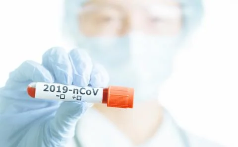 Scientist in protective gloves showing test tube with blood for 2019-nCoV ana Stock Photos