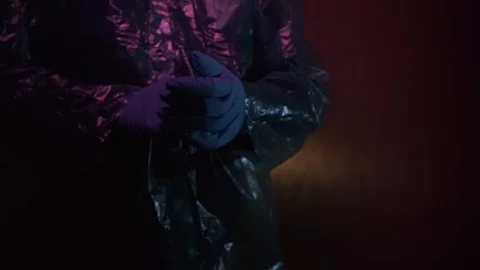 Scientist in protective suit on dark red background. Coronavirus protection Video stock 127117407