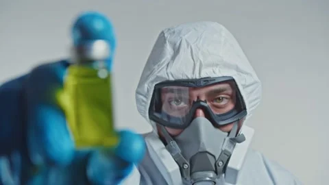 Scientist in a protective suit, goggle and respirator holding a vaccine. Stock Footage 144113994