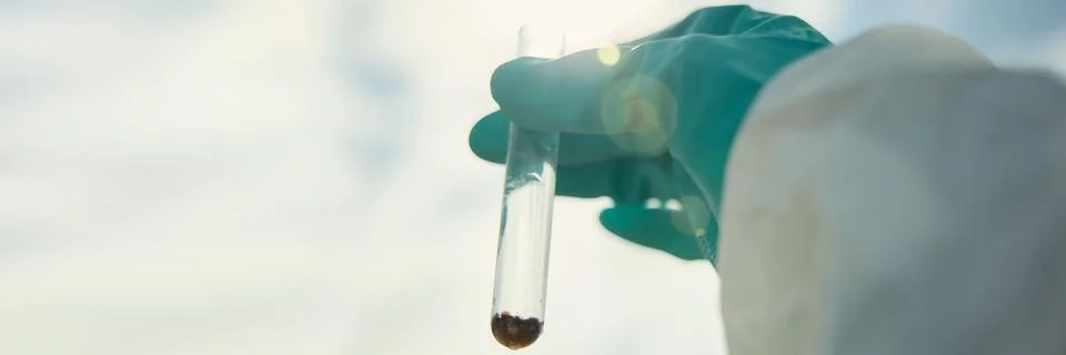Scientist in Protective Suit Holding Test Tube with Soil Sample Stock Photos
