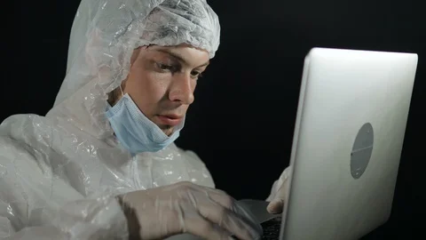 Scientist in protective suit with laptop in hands develops a vaccine against 스톡 동영상 129848332