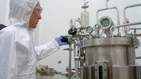 Scientist in protective suits working on vat Stockbeeldmateriaal 55516555