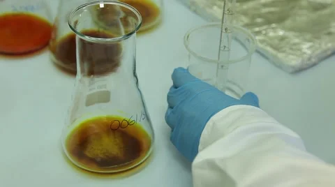 Scientist put liquid droplets from graduated pipette in Erlenmeyer Flask Stock Footage 61713186