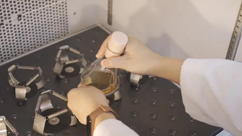 Scientist put Sollution container into Orbital Shaker 50fps Stock-Footage 247403981