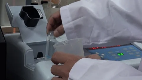 A scientist is putting a sample of water in a machine. Laboratory. Stock Footage 76824250