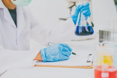 The scientist is recording the scientific value on a note. In an experiment i Stock Photos