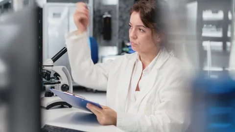 Scientist records observations in lab, doing validation of clinical results Stock Footage 320722691