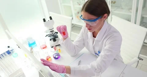 Scientist researcher entering data into computer holds vaccine Stock Footage 253501687
