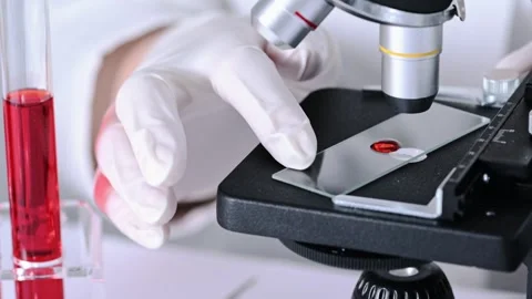 Scientist researching blood sample under microscope in laboratory. Stock Footage 273578224