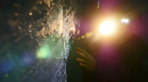 Scientist researching ice inside glacier cave tunnel using flashlight 動画素材 64799576