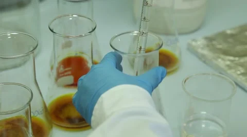Scientist shaking Erlenmeyer Flask after put liquid droplets graduated pipette Stock Footage 61713014