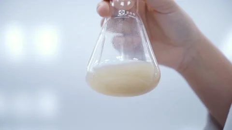 Scientist shaking yellow liquid in erlenmeyer flask extra close up slow motion Stock-Footage 158913733