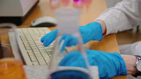 A scientist sitting at a computer and conducting research in a modern laboratory Stockbeeldmateriaal 275185051