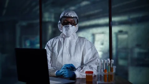 Scientist sitting in the laboratory at the table with test tubes and computer Stock Footage 95352049