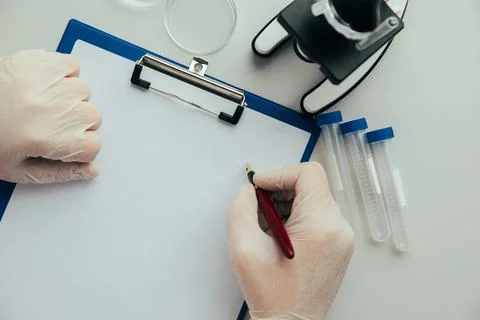 A scientist sitting at a table in a laboratory with test-tubes Stock Photos