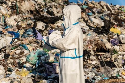 A scientist is standing on a garbage dump. Pile of garbage. City landfill. 库存照片