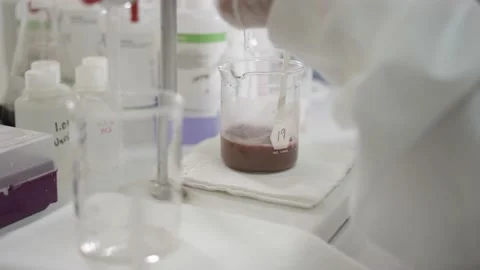 Scientist stirring solution in beaker in a real lab Stock Footage 144352153