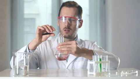 Scientist stirs the red liquid in the flask Stock-Footage 73111130