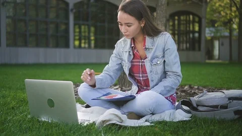Scientist student working with computer, writting, sitting outdoors. Stock Footage 101796065